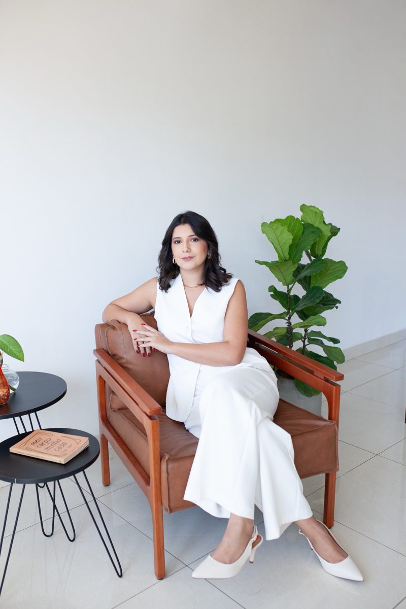 Andressa Cristina, Consultora de Imagem, sentada numa poltrona de couro